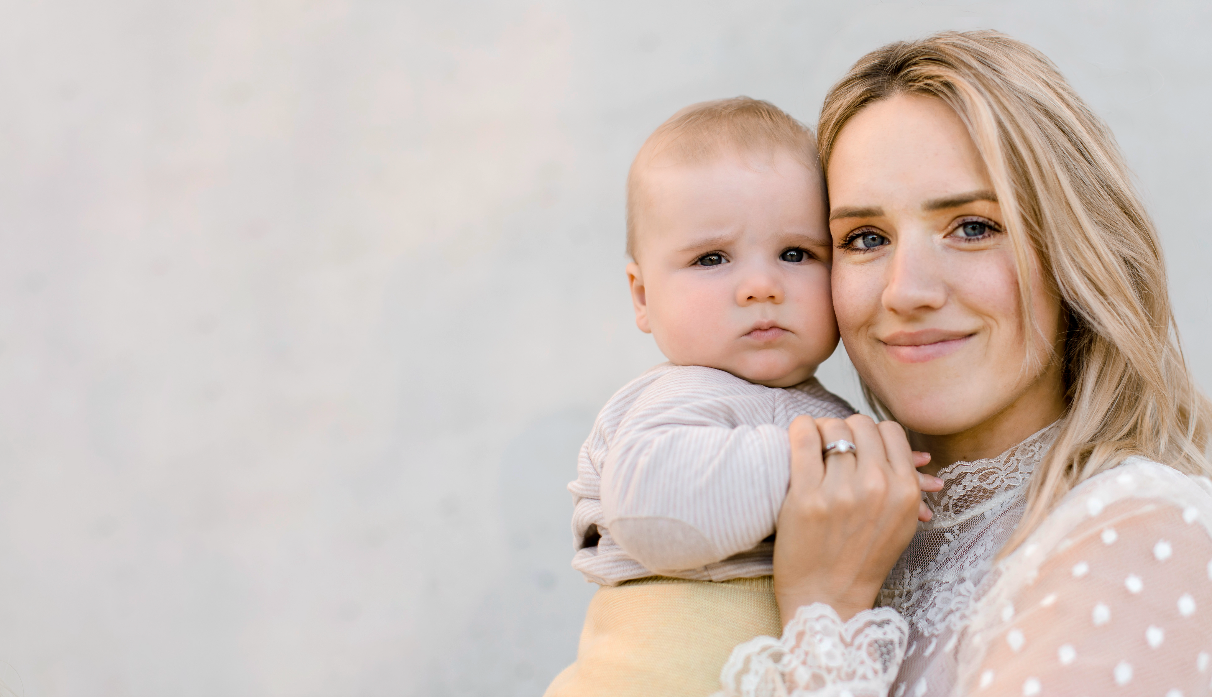 young blond mother holding a cute baby